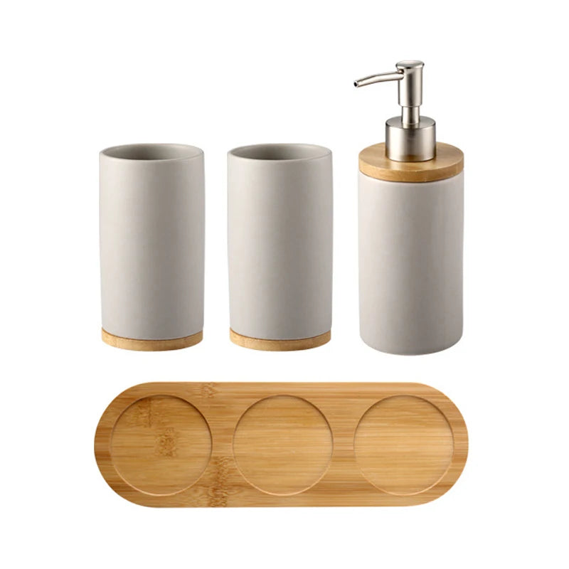 Ceramic bathroom accessory set with two warm ivory tumblers, soap dispenser, and bamboo base for calm luxury bathroom organization