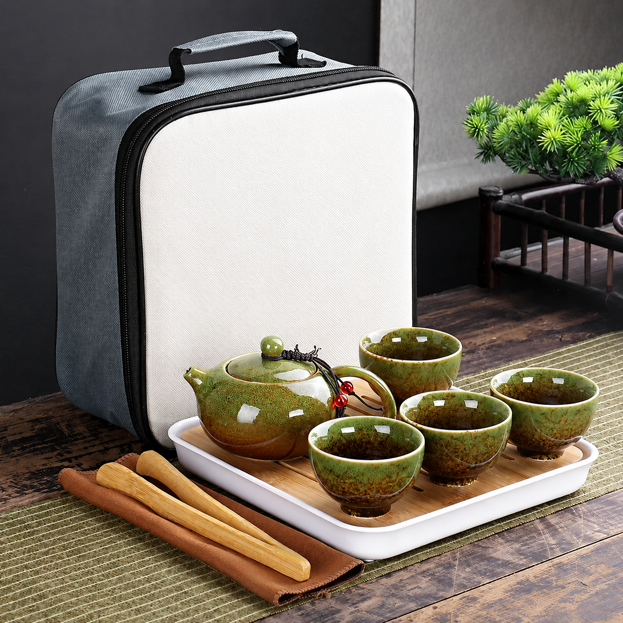 Portable ceramic tea set with green teapot and cups, travel storage bag, wooden tray, and calm home tea ritual styling