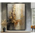 Textured abstract canvas wall art in gold, beige, grey and black, hand painted acrylic, black frame, displayed on grey wall with decorative vase
