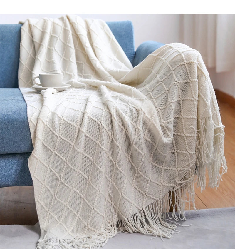 Neutral tassel throw blanket styled in a calm living room, supporting slower evenings and screen-free wind-down moments.