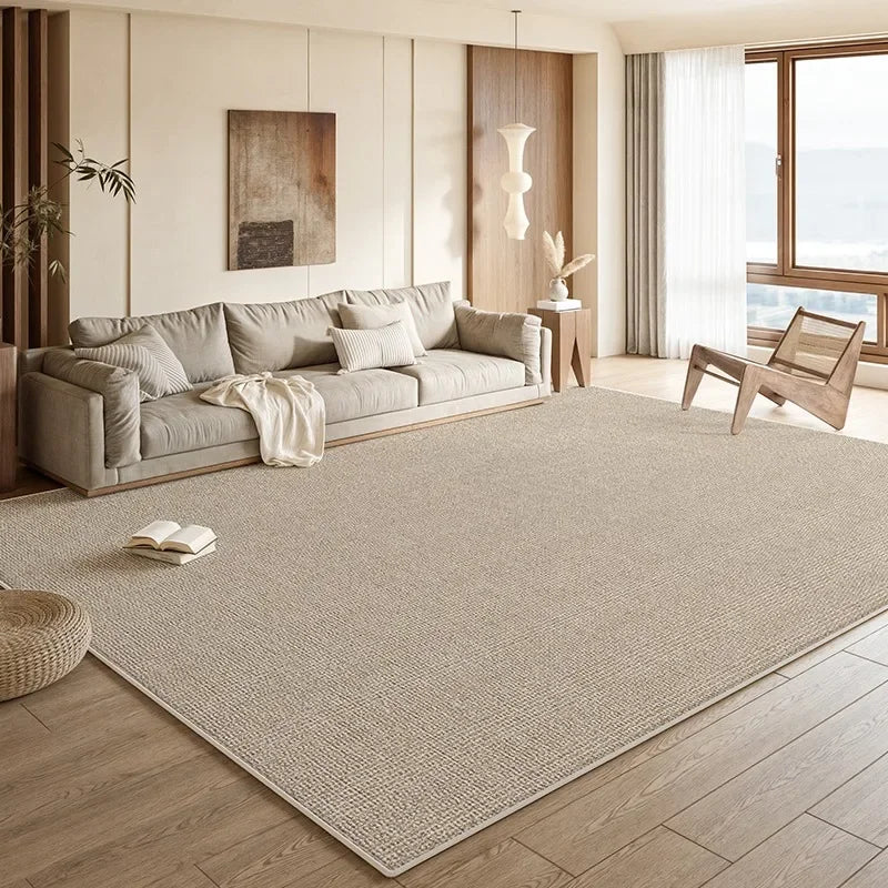 Premium neutral area rug covering a spacious designer living room floor with soft beige texture and warm natural light