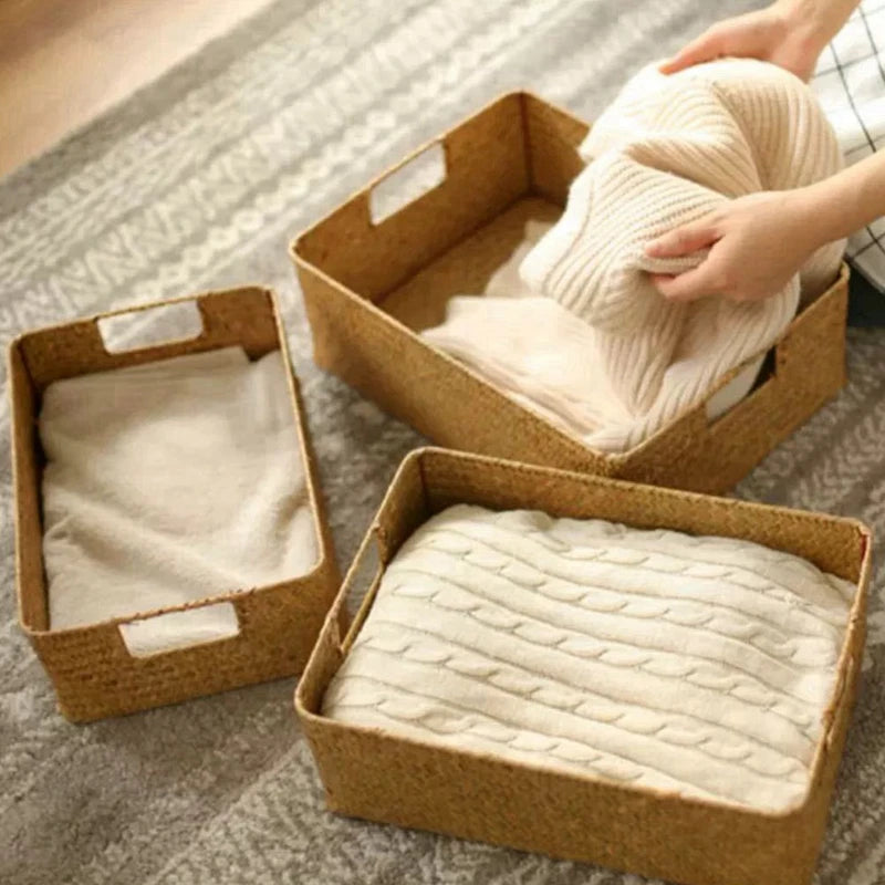 Woven seagrass storage baskets on wooden shelves with folded ivory towels in a luxury neutral bedroom