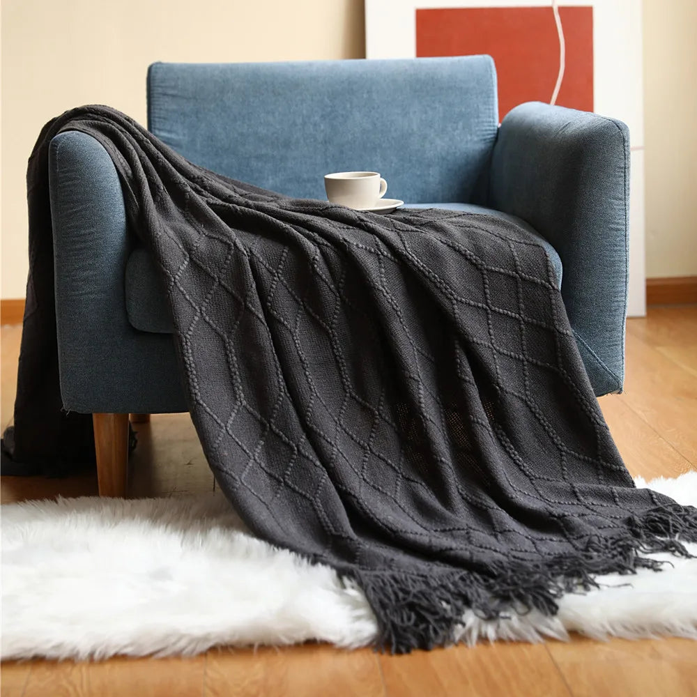 Elegant knitted blanket with fringe tassels displayed on a modern sofa for a calm, premium Usfera home essential look.