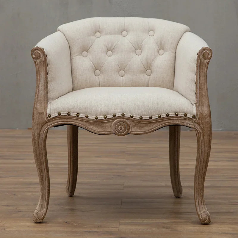 Premium upholstered accent chair with solid wood frame, curved arms, button-tufted back, and refined French-style design