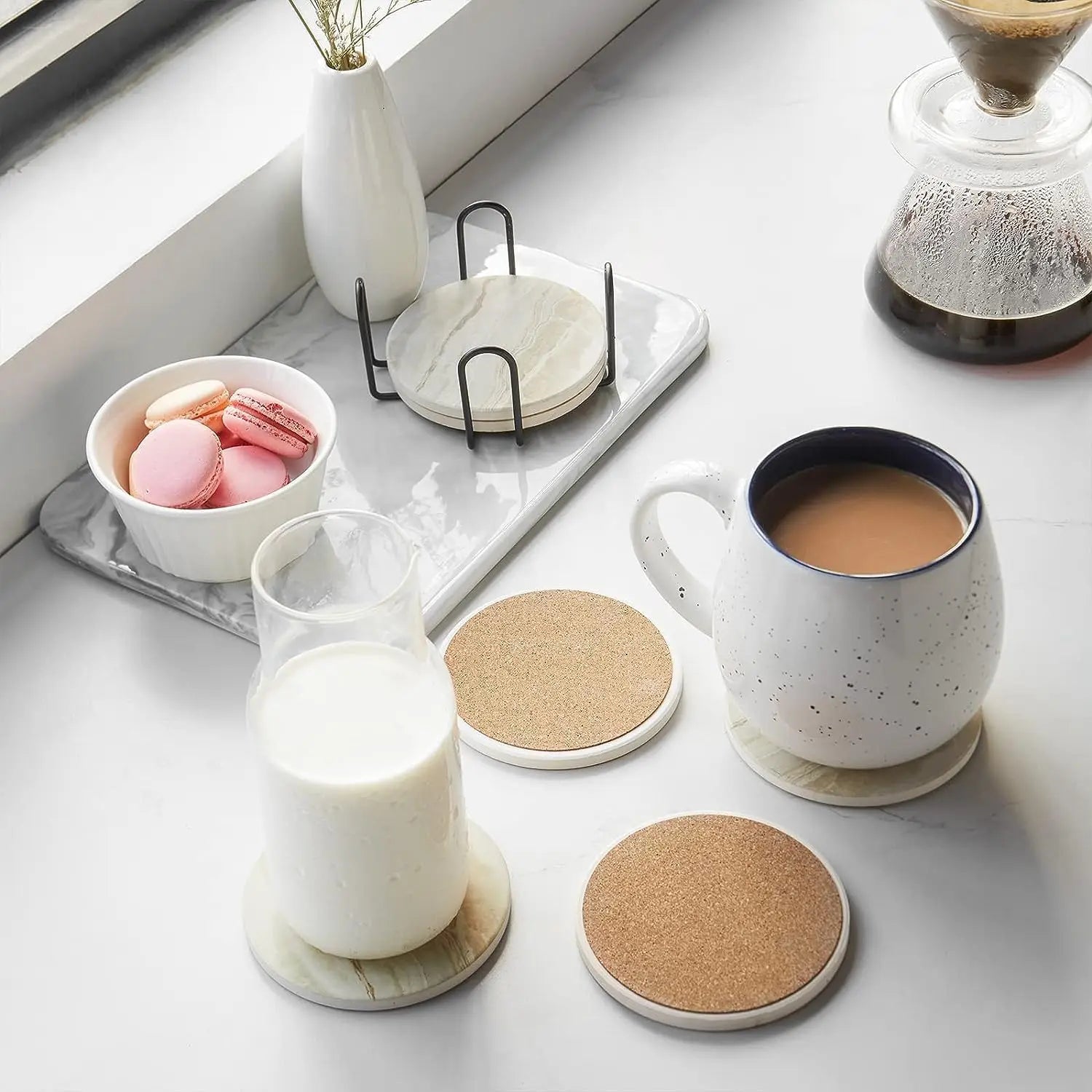 Marble-style ceramic coaster set on a luxury coffee table with mugs, flowers, books, and soft neutral living room decor