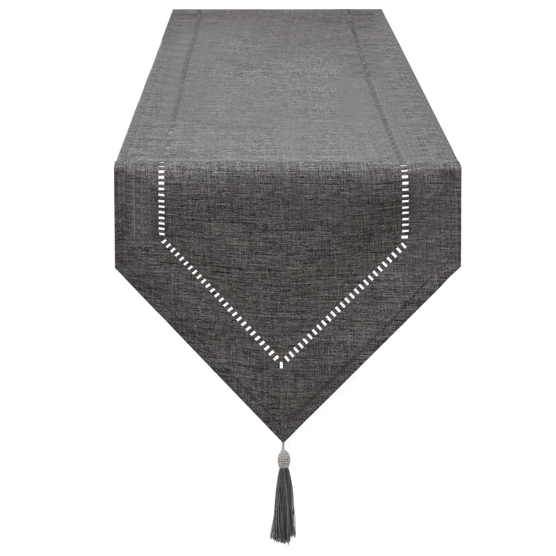 Elegant table runner in dark gray linen, styled dining table with neutral ceramic plates and soft candlelight