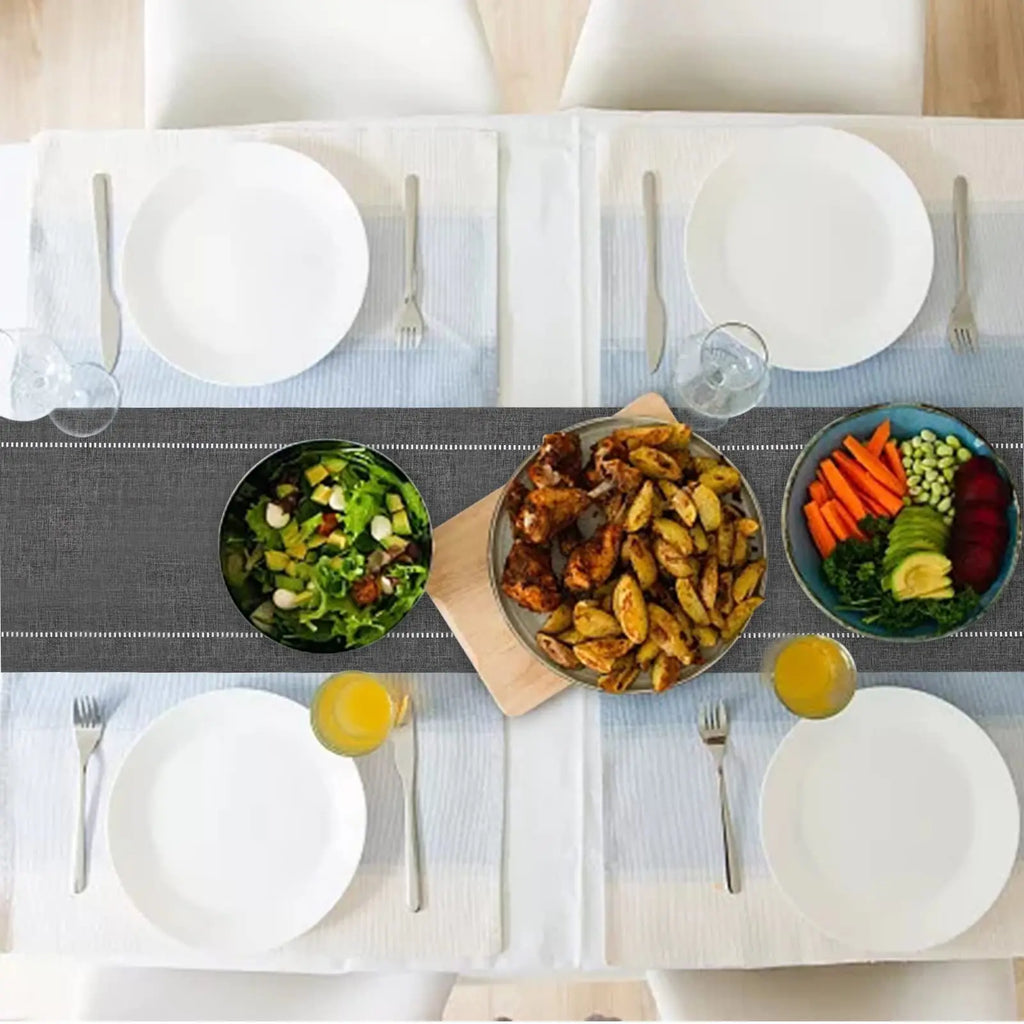 Premium linen table runner in charcoal, close-up of hemstitch border detail on rustic oak dining table
