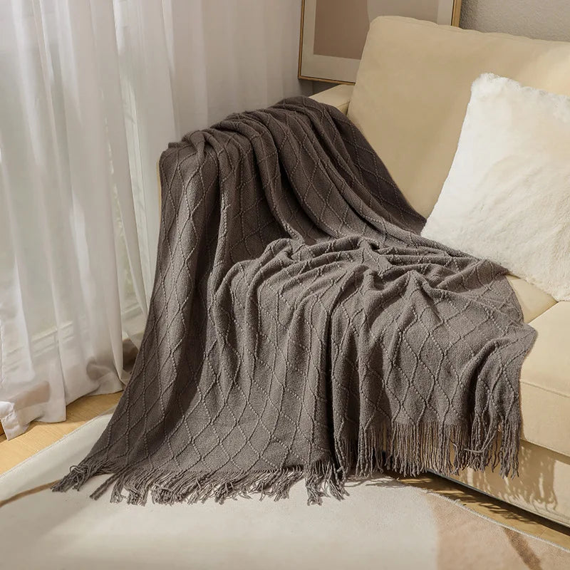 Cream knitted throw blanket folded neatly on a bed, ideal for bedroom layering, quiet routines, and cozy family comfort.
