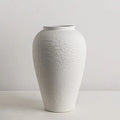 neutral ceramic vase set in cozy living room with soft lighting and natural materials