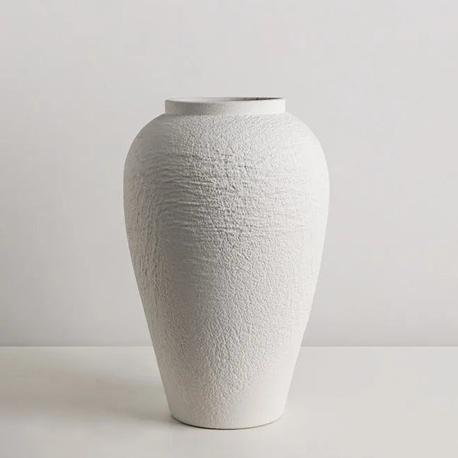 neutral ceramic vase set in cozy living room with soft lighting and natural materials