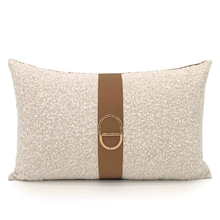 Textured beige lumbar pillow cover with coffee band and gold buckle detail on a calm luxury sofa