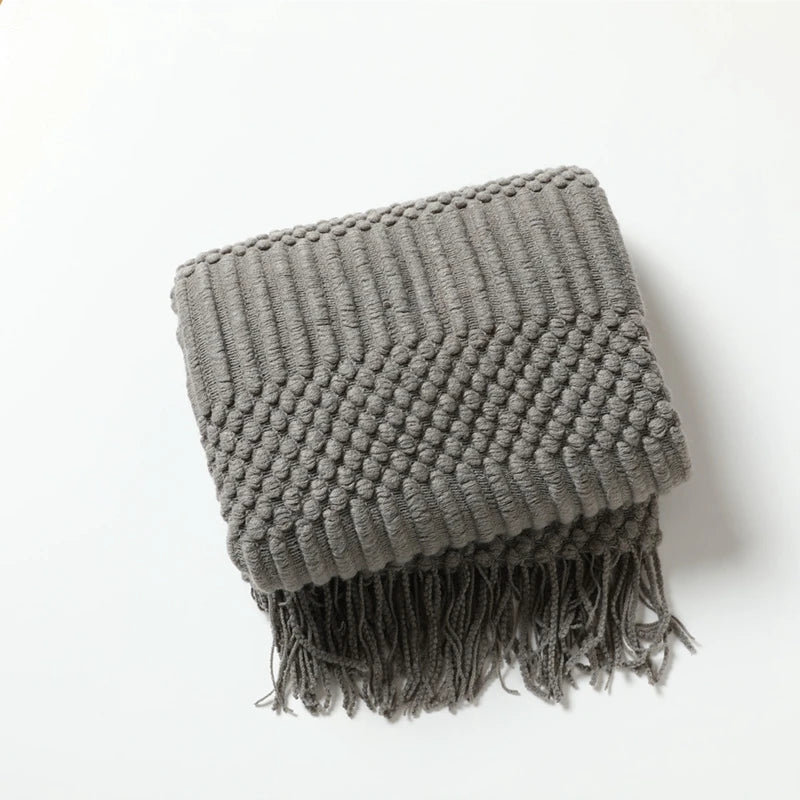 Nordic-style sofa throw blanket with textured knit and tassel edges, ideal for warmer evenings and relaxed home spaces.