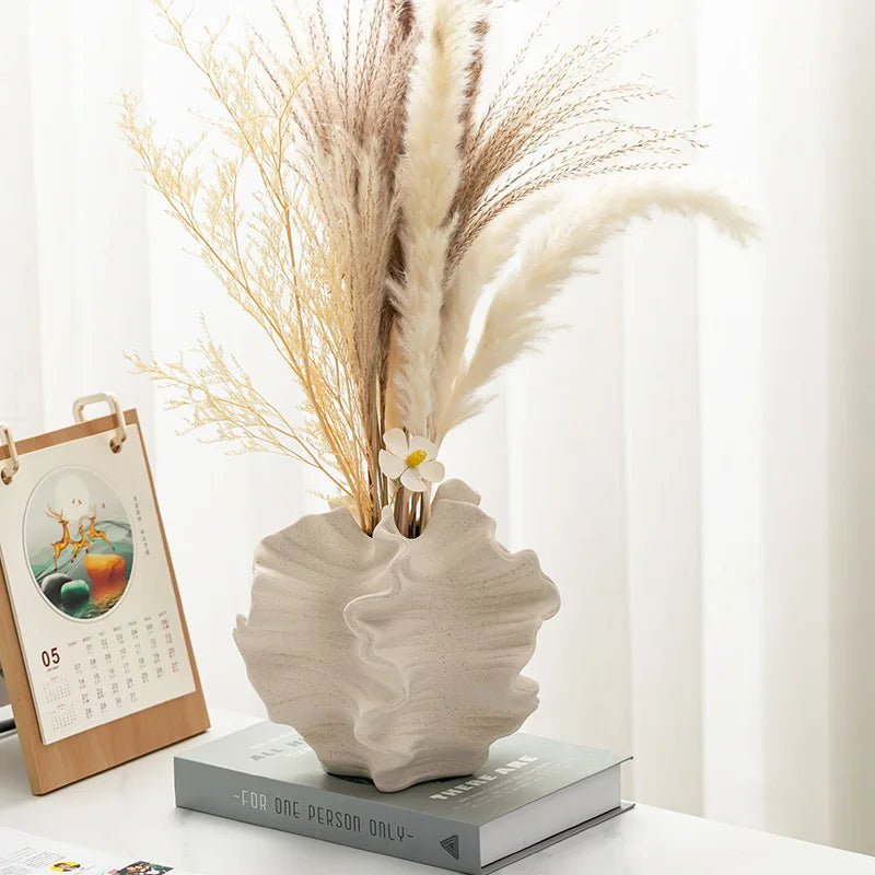 Ivory wavy ceramic vase styled in a premium family living room with warm neutral decor and USFERA branding on a separate object