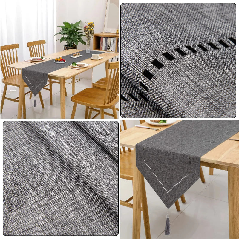 Dark gray linen table runner with tassel detail, elegant dining table styled with eucalyptus stems and glass candle holders
