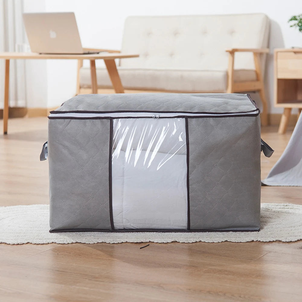 Gray quilted blanket storage bag with side handles, used for organizing bedding, textiles, and calm home essentials in a cozy family space.