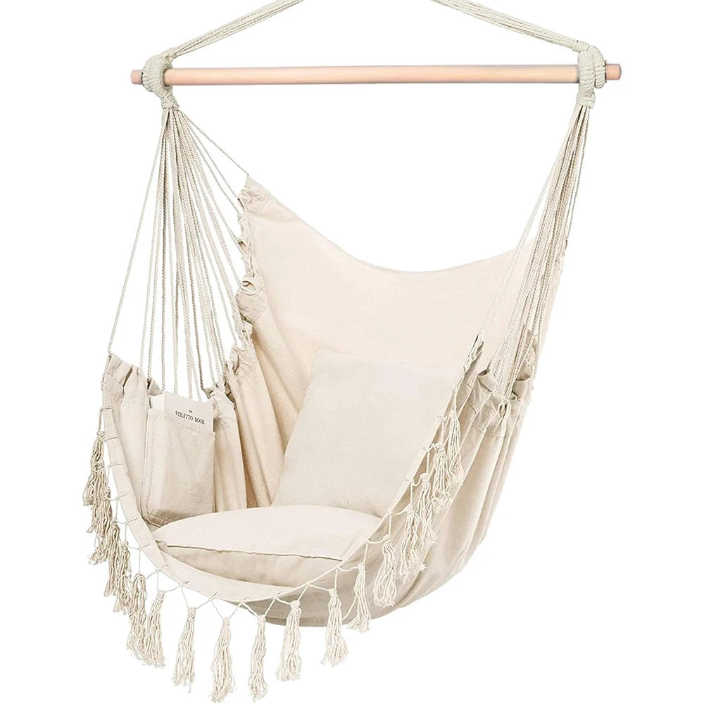 White macrame hanging chair styled in a calm luxury outdoor terrace with neutral cushions, wood accents, and soft natural light