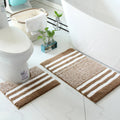 Neutral bathroom rug set styled with ivory towels, wood accents, and soft natural light