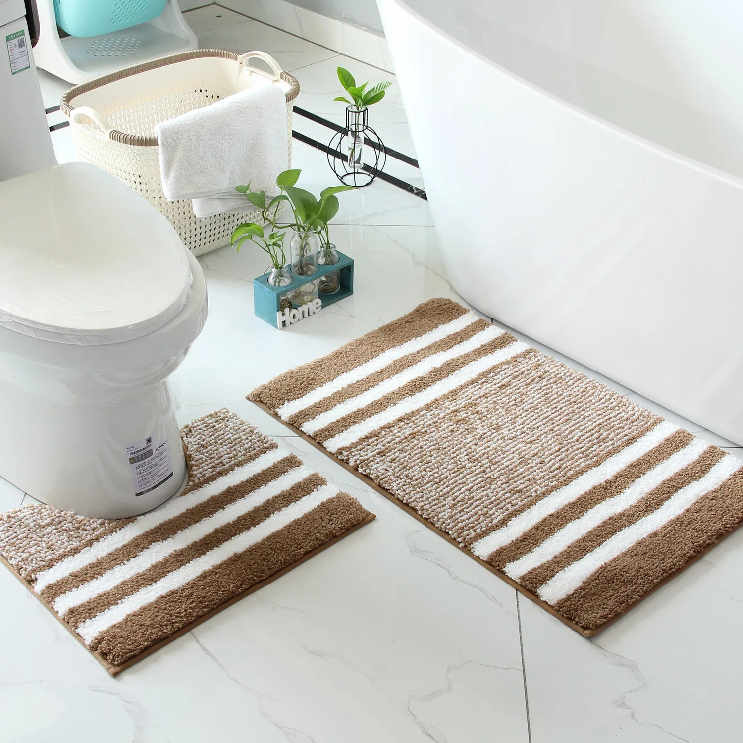 Neutral bathroom rug set styled with ivory towels, wood accents, and soft natural light
