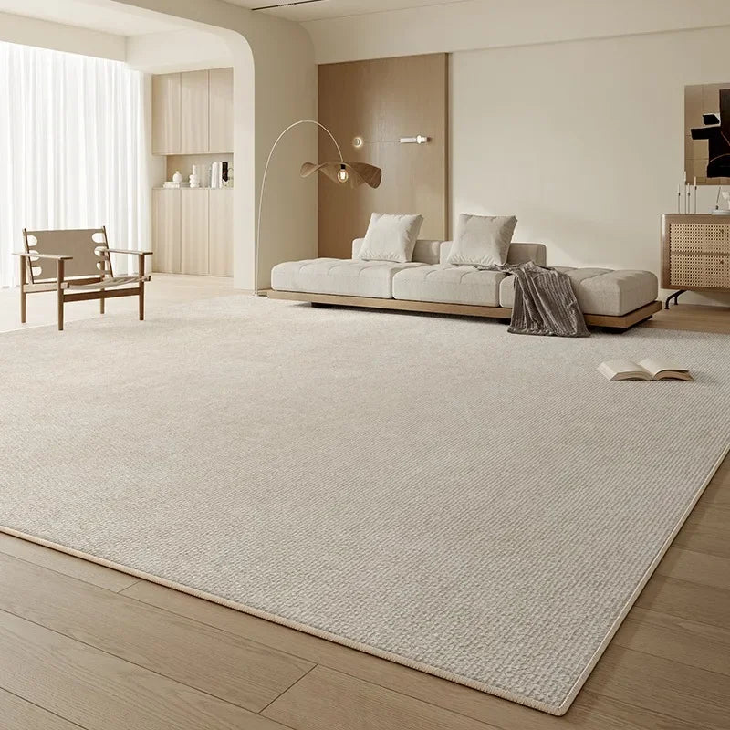 Large ivory beige rug styled under a sofa and coffee table in a quiet luxury family living room