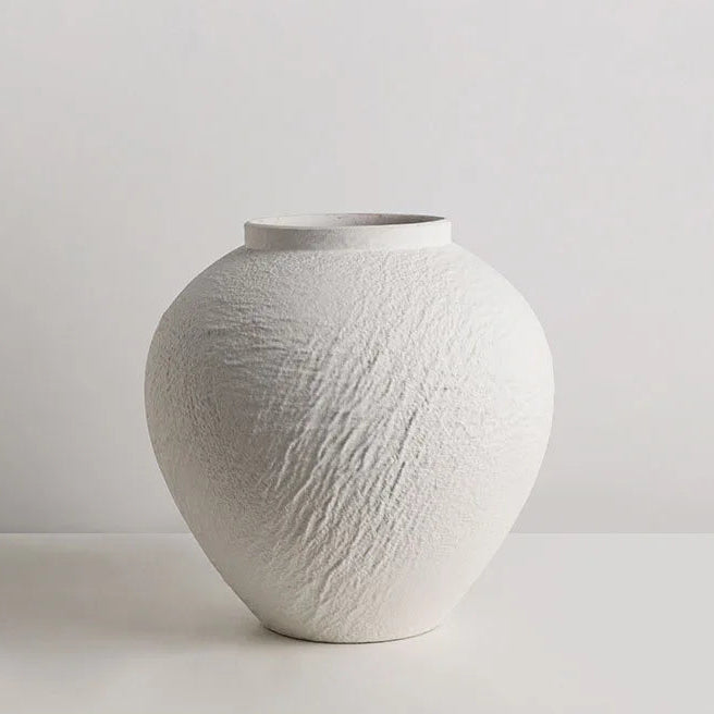 ceramic vase set styled on coffee table with book and warm natural light in calm home interior