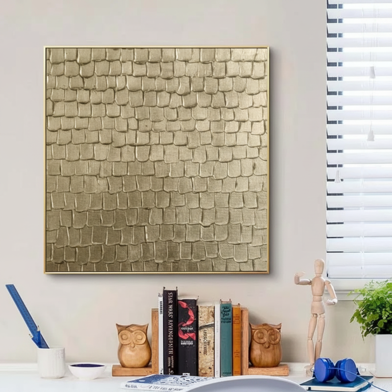 3D gold leaf textured canvas wall art with gold frame hanging above desk in modern home office
